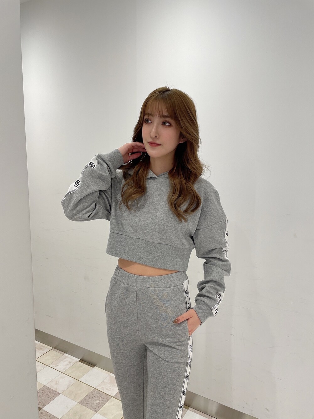 グレー系のパーカー、グレー系のその他パンツ、ホワイト系のパンプスを着用したレディースの冬コーディネートの2枚目の写真