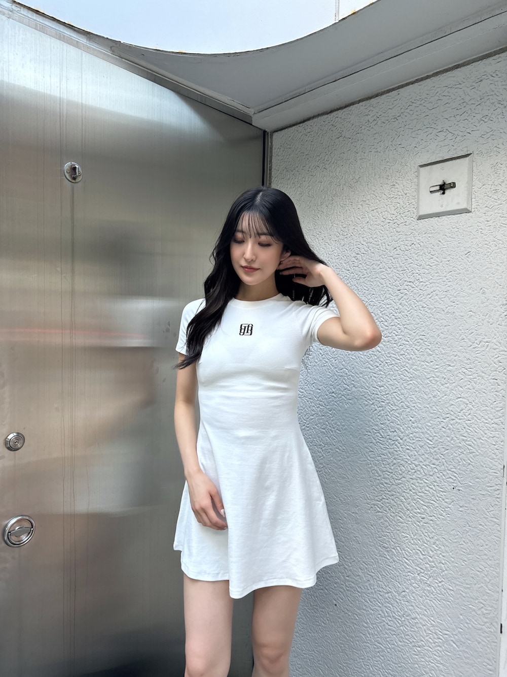 ホワイト系のワンピース、ブラック系のブーツを着用したレディースの夏コーディネートの4枚目の写真