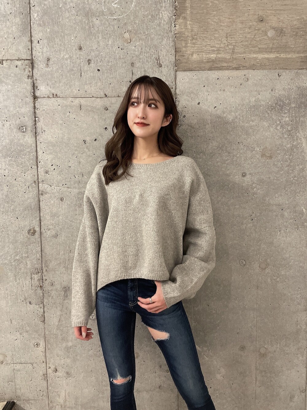 グレー系のニット/セーター、ブルー系のデニムパンツ、ブラック系のブーツを着用したレディースの冬コーディネートの4枚目の写真