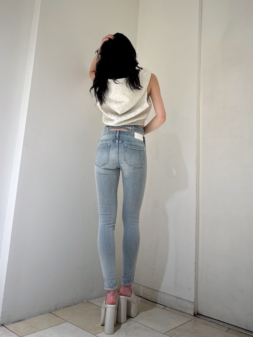 グレー系のTシャツ/カットソー、ホワイト系のキャミソール、ブルー系のデニムパンツを着用したレディースの夏コーディネートの2枚目の写真