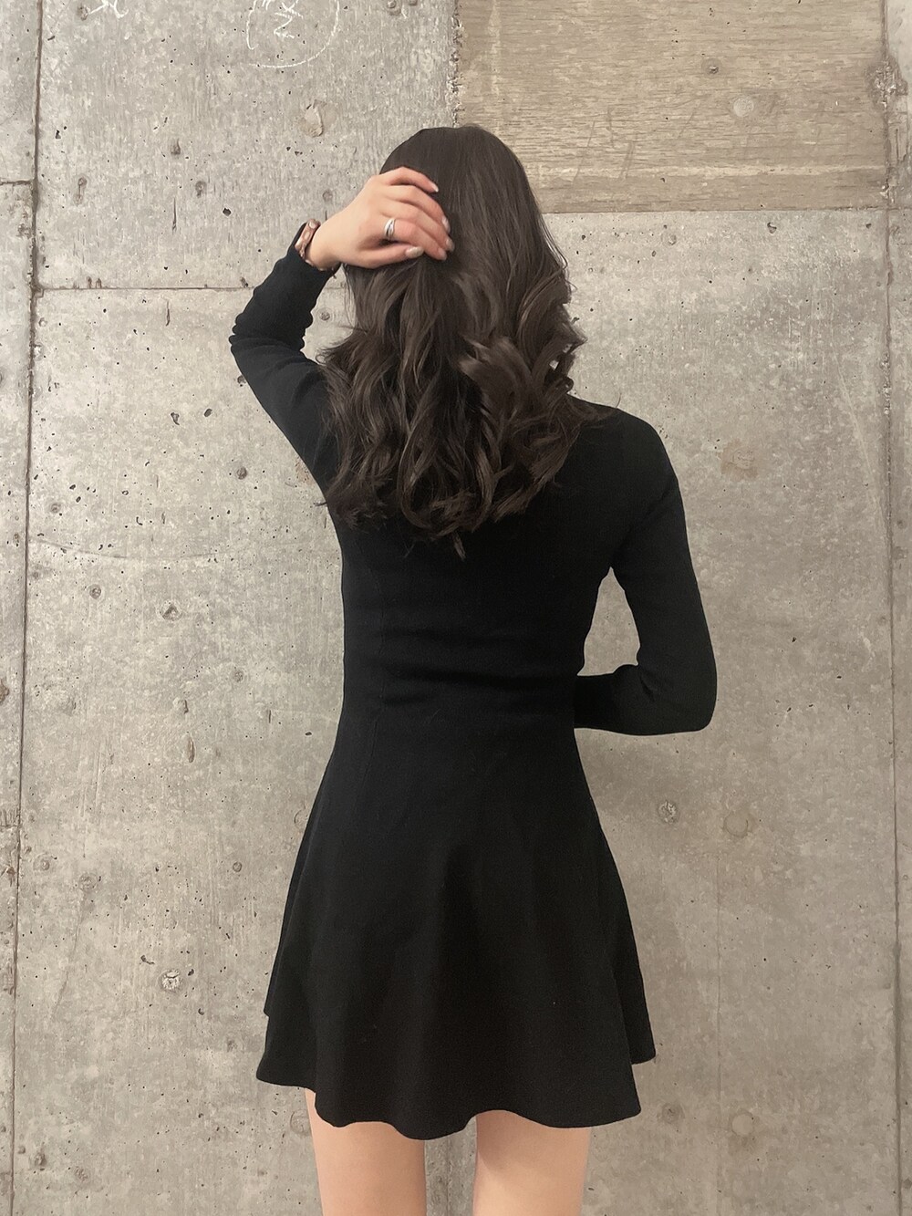 ホワイト系のダウンジャケット/コート、ブラック系のワンピース、ブラック系のブーツを着用したレディースの冬コーディネートの7枚目の写真