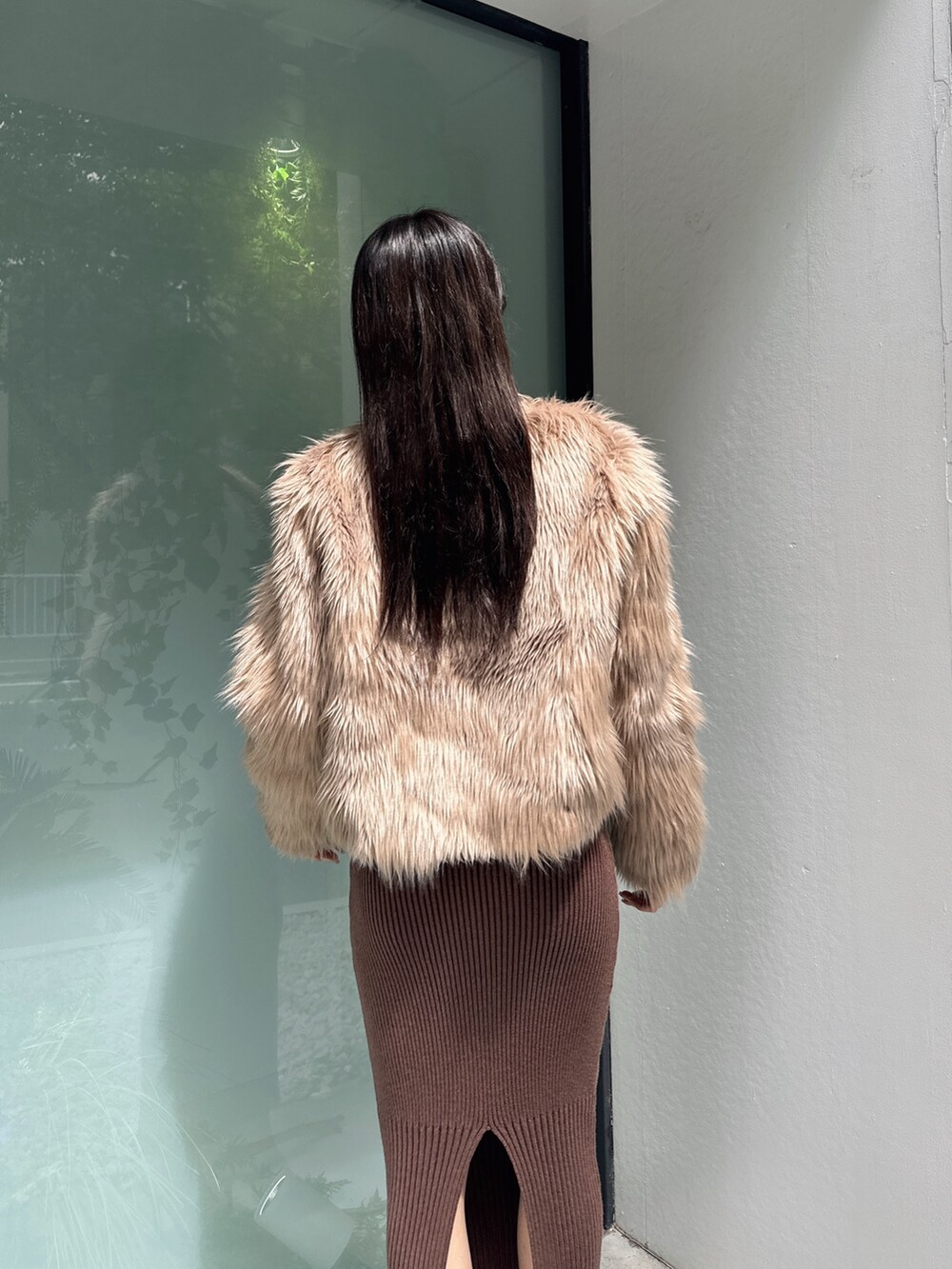 ベージュ系のライダースジャケット、ブラウン系のワンピース、ブラック系のパンプスを着用したレディースの秋コーディネートの4枚目の写真