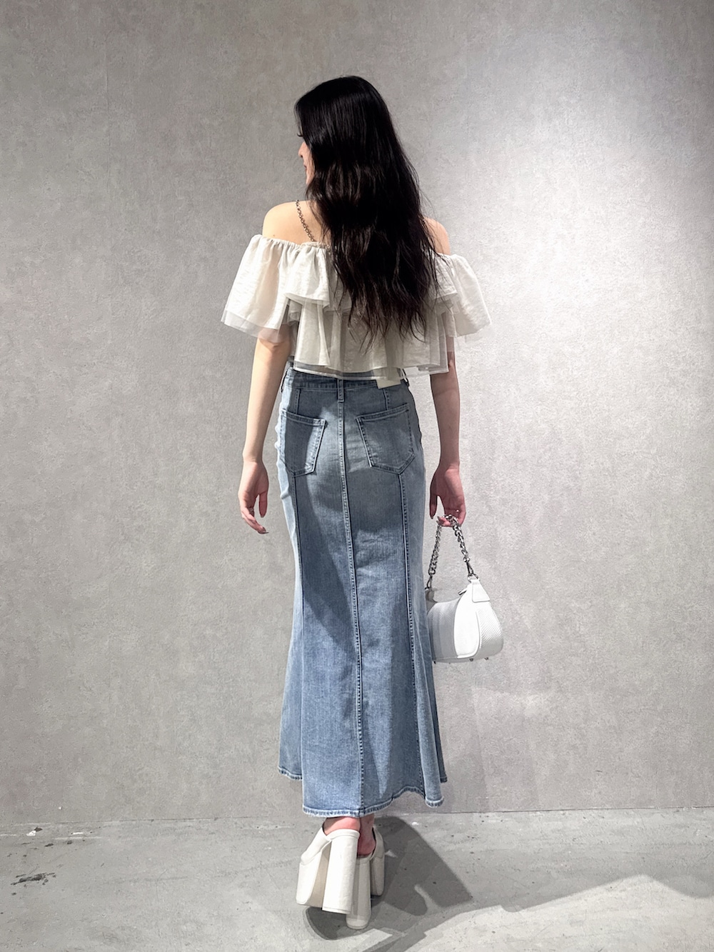 ベージュ系のシャツ/ブラウス、ブルー系のデニムスカート、ホワイト系のサンダルを着用したレディースの夏コーディネートの2枚目の写真