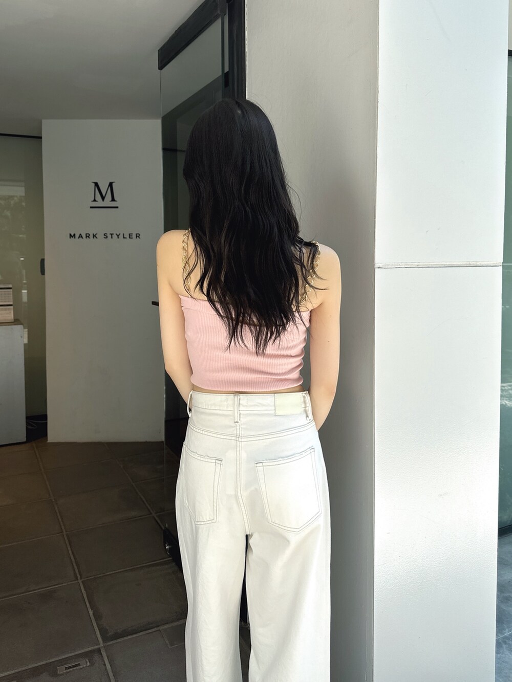 ピンク系のキャミソール、ホワイト系のデニムパンツ、ホワイト系のパンプスを着用したレディースの夏コーディネートの3枚目の写真