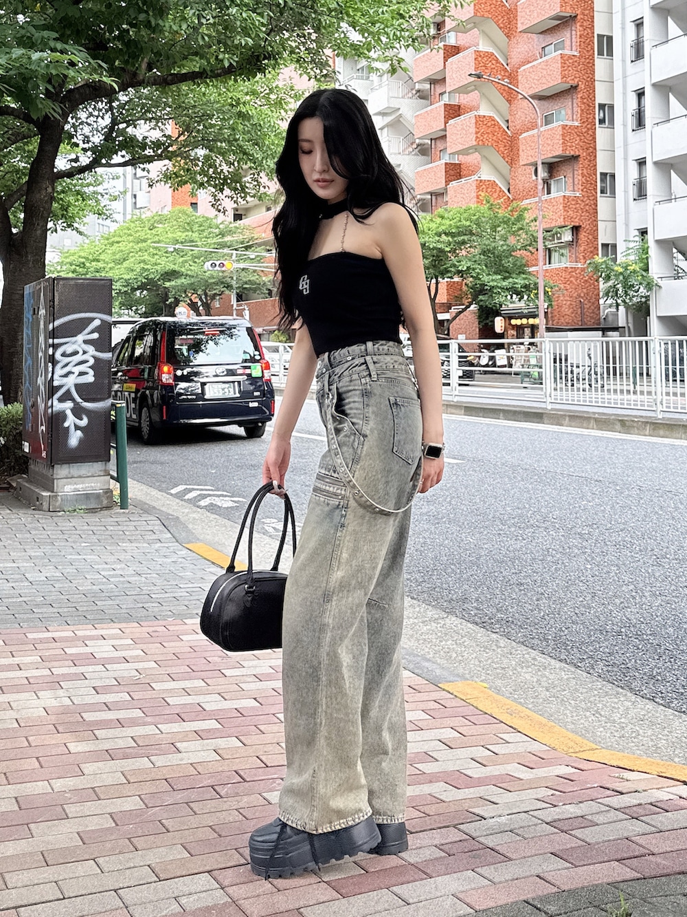 ブルー系のデニムパンツ、ブラック系のキャミソール、ブラック系のスニーカーを着用したレディースの夏コーディネートの2枚目の写真