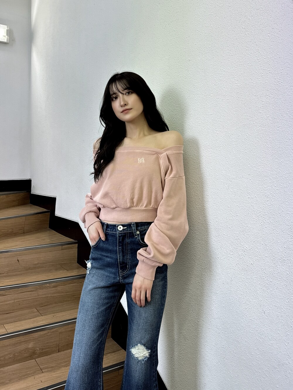 ピンク系のスウェット、ブルー系のデニムパンツ、ブラック系のブーツを着用したレディースの夏コーディネートの3枚目の写真