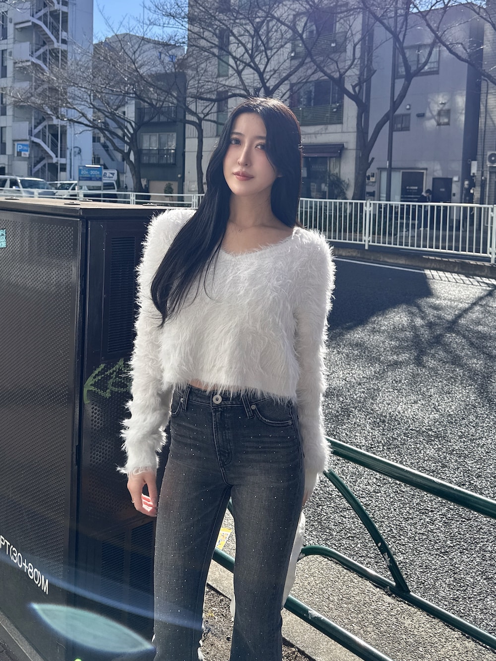 ホワイト系のニット/セーター、ブラック系のデニムパンツ、ブラック系のブーツを着用したレディースの冬コーディネートの2枚目の写真