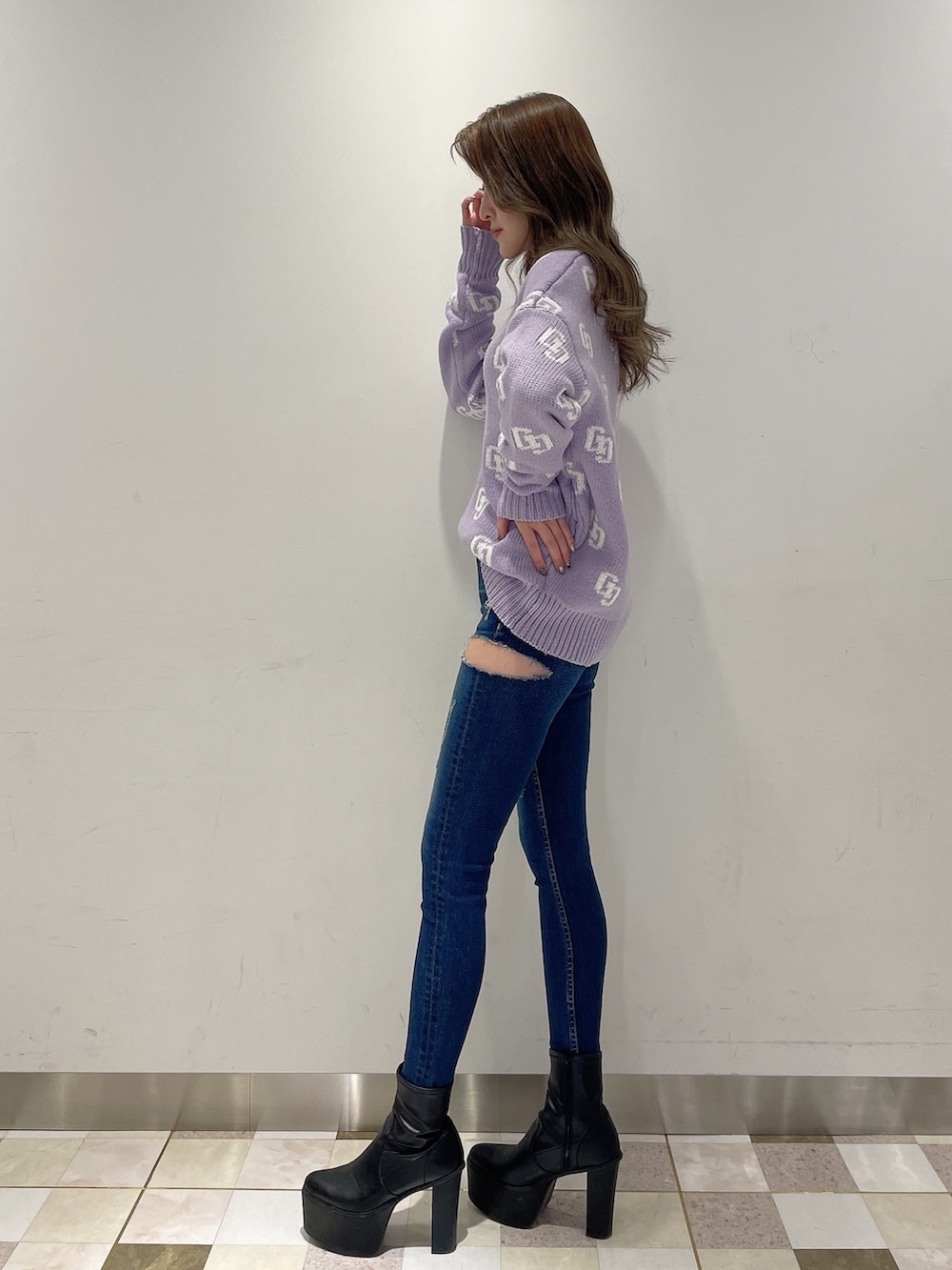 パープル系のニット/セーター、ブルー系のデニムパンツ、ブラック系のブーツを着用したレディースの冬コーディネートの2枚目の写真