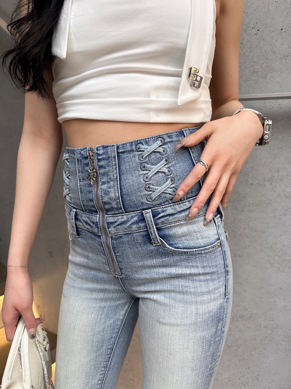 ホワイト系のTシャツ/カットソー、ブルー系のデニムパンツ、ホワイト系のハンドバッグを着用したレディースの春コーディネートの4枚目の写真