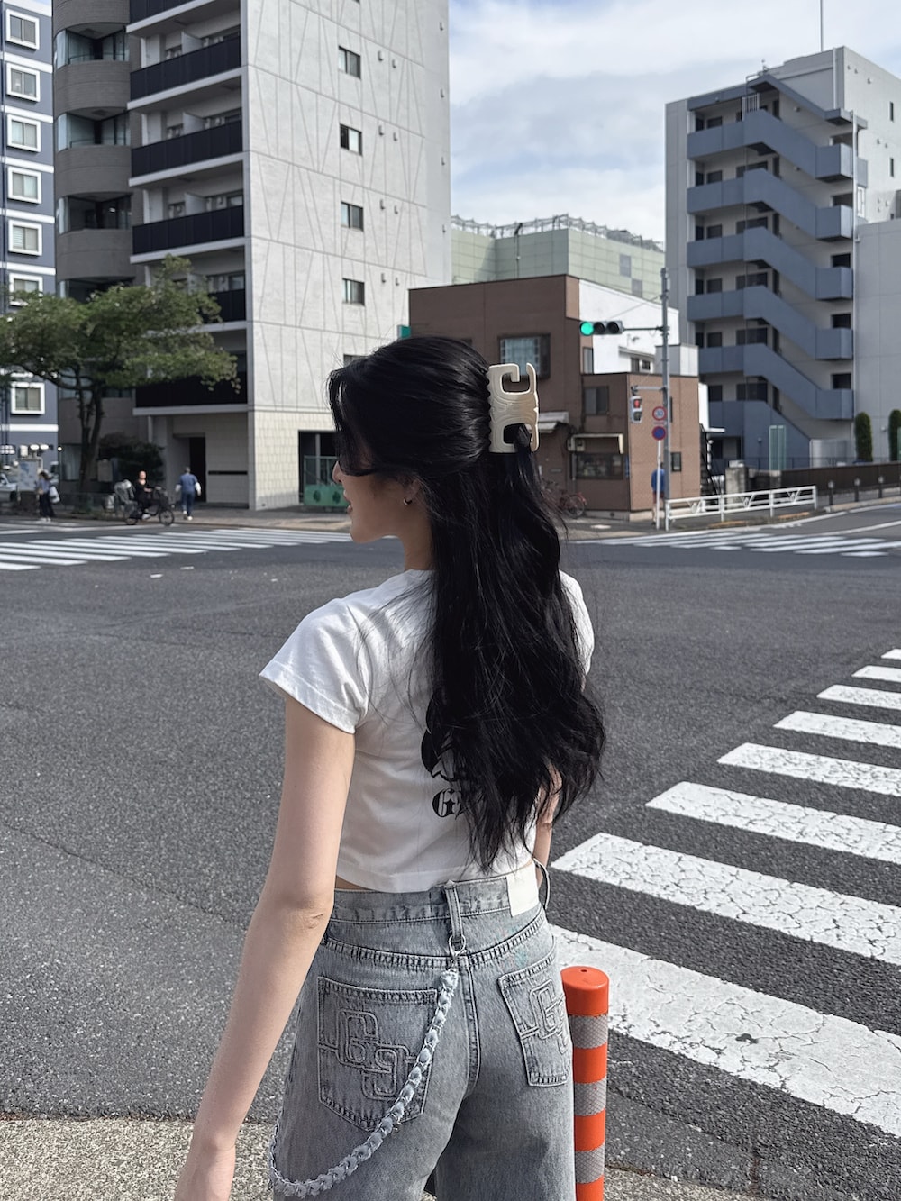 ホワイト系のTシャツ/カットソー、ブルー系のデニムパンツ、ブラック系のスニーカーを着用したレディースの春コーディネートの3枚目の写真