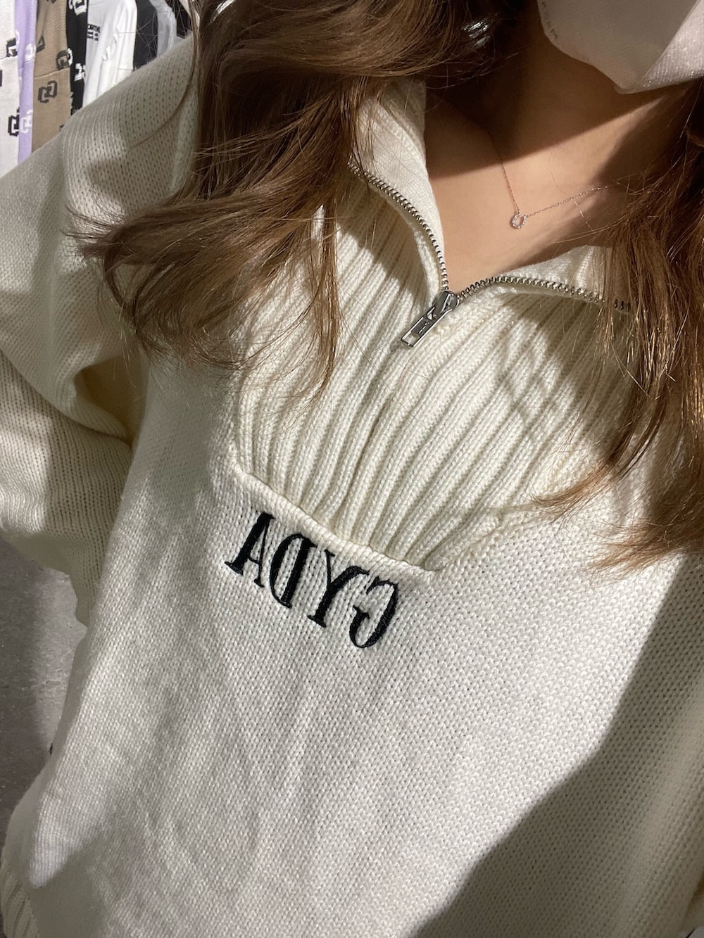 ホワイト系のニット/セーター、ブラック系のスカート、ブラック系のブーツを着用したレディースの冬コーディネートの3枚目の写真