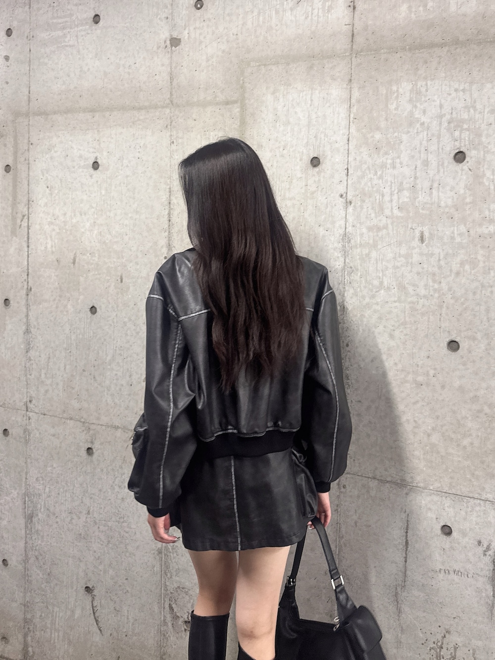 ブラック系のスカート、ブラック系のブーツ、ブラック系のブルゾンを着用したレディースの秋コーディネートの6枚目の写真