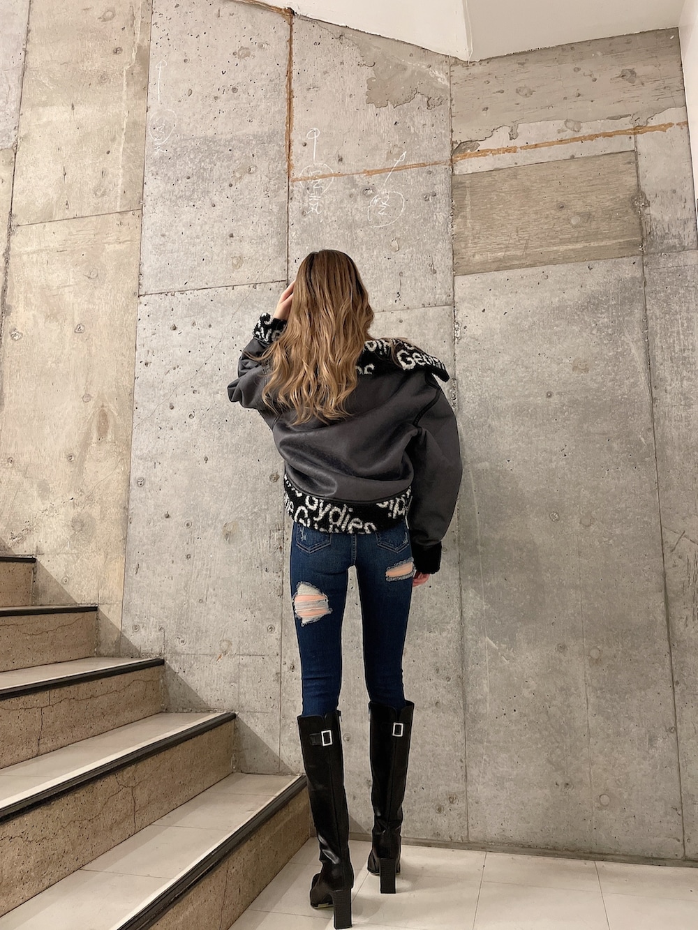 ブラック系のブルゾン、グレー系のスウェット、ブルー系のデニムパンツを着用したレディースの秋コーディネートの3枚目の写真