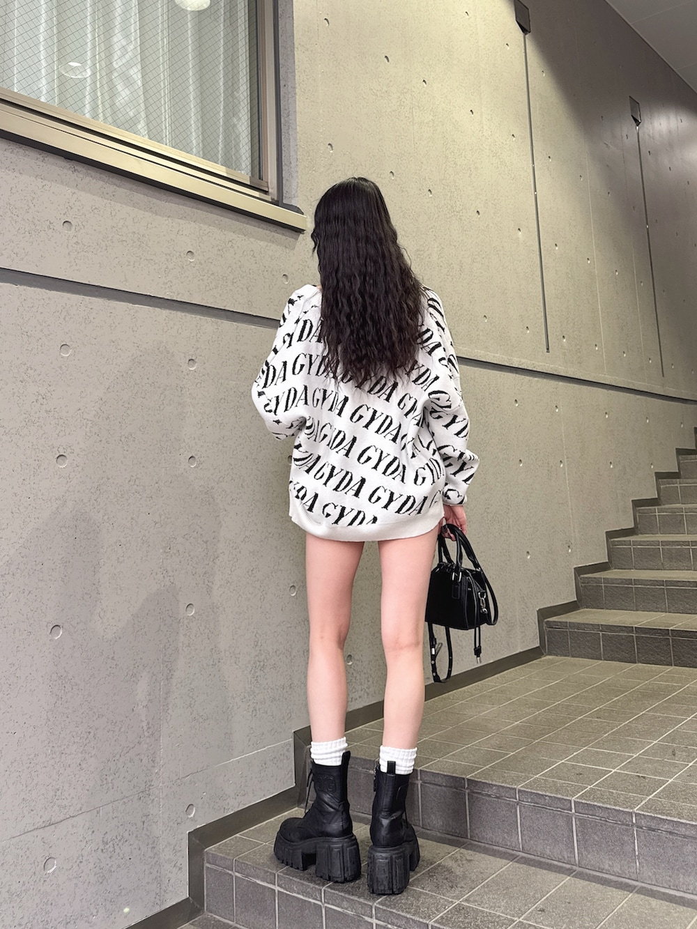 ホワイト系のカーディガン/ボレロ、ブラック系のTシャツ/カットソー、ブラック系のデニムスカートを着用したレディースの春コーディネートの4枚目の写真