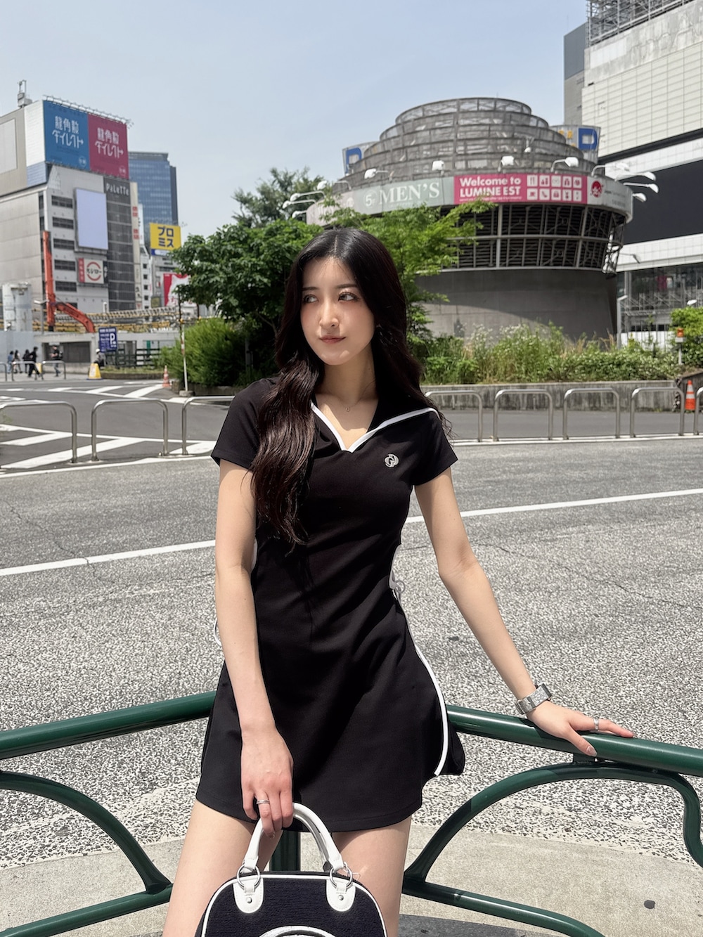 ブラック系のワンピース、ブラック系のハンドバッグ、ブラック系のスニーカーを着用したレディースの春コーディネートの4枚目の写真