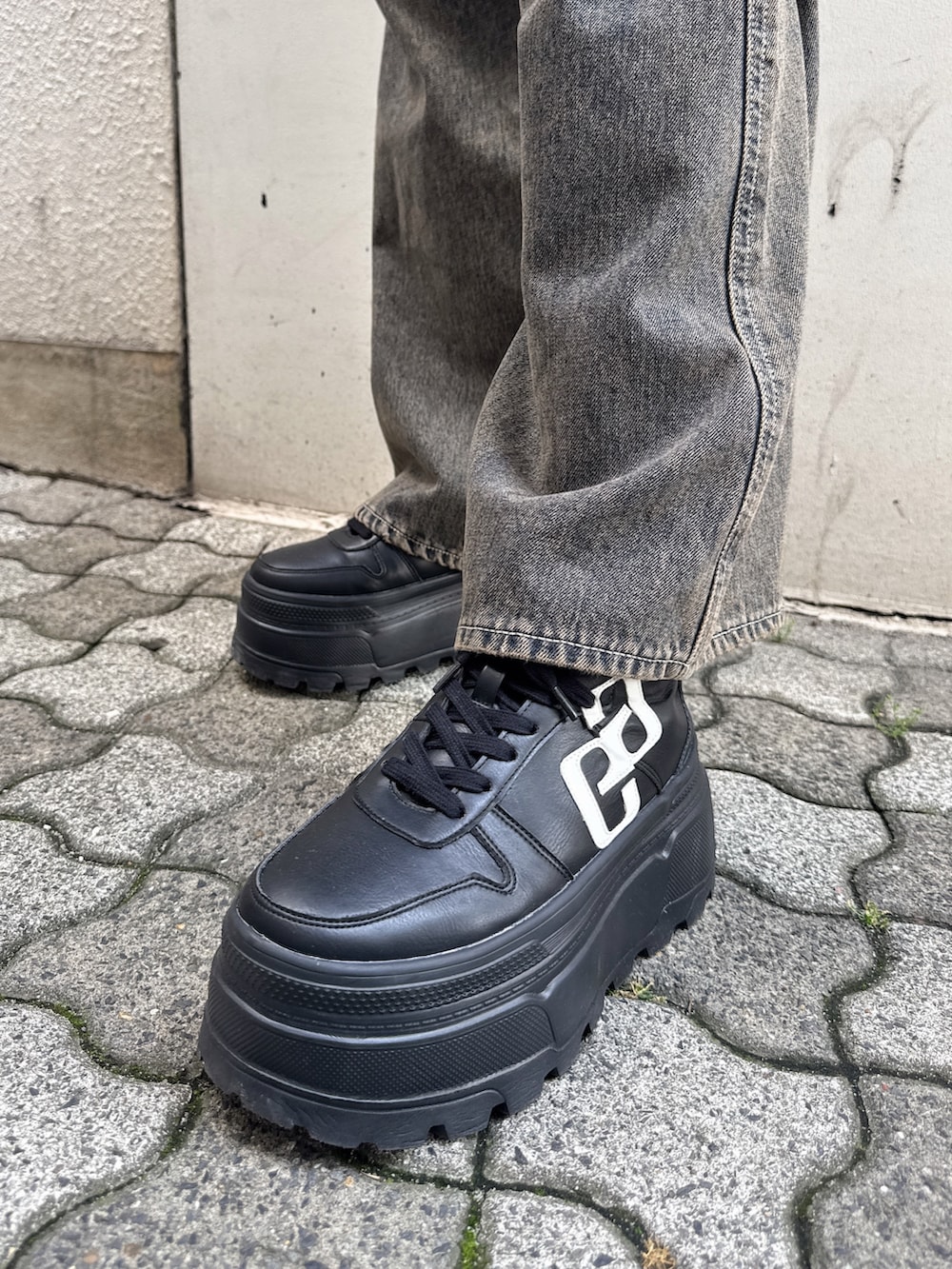ブルー系のデニムパンツ、ブラック系のキャミソール、ブラック系のスニーカーを着用したレディースの夏コーディネートの6枚目の写真