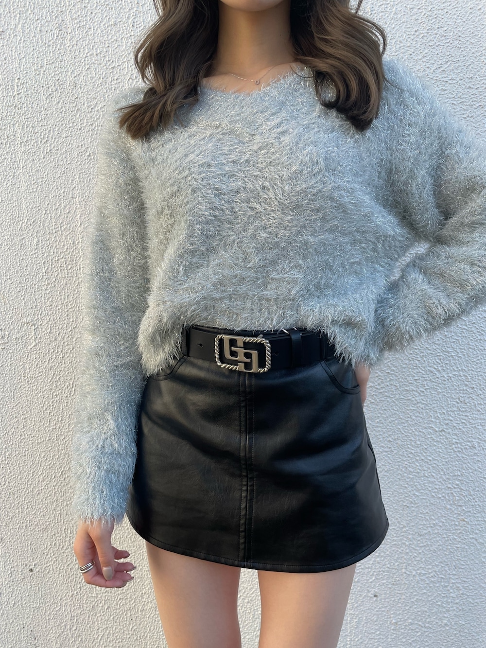 グレー系のニット/セーター、ブラック系のブーツ、ブラック系のスカートを着用したレディースの秋コーディネートの5枚目の写真