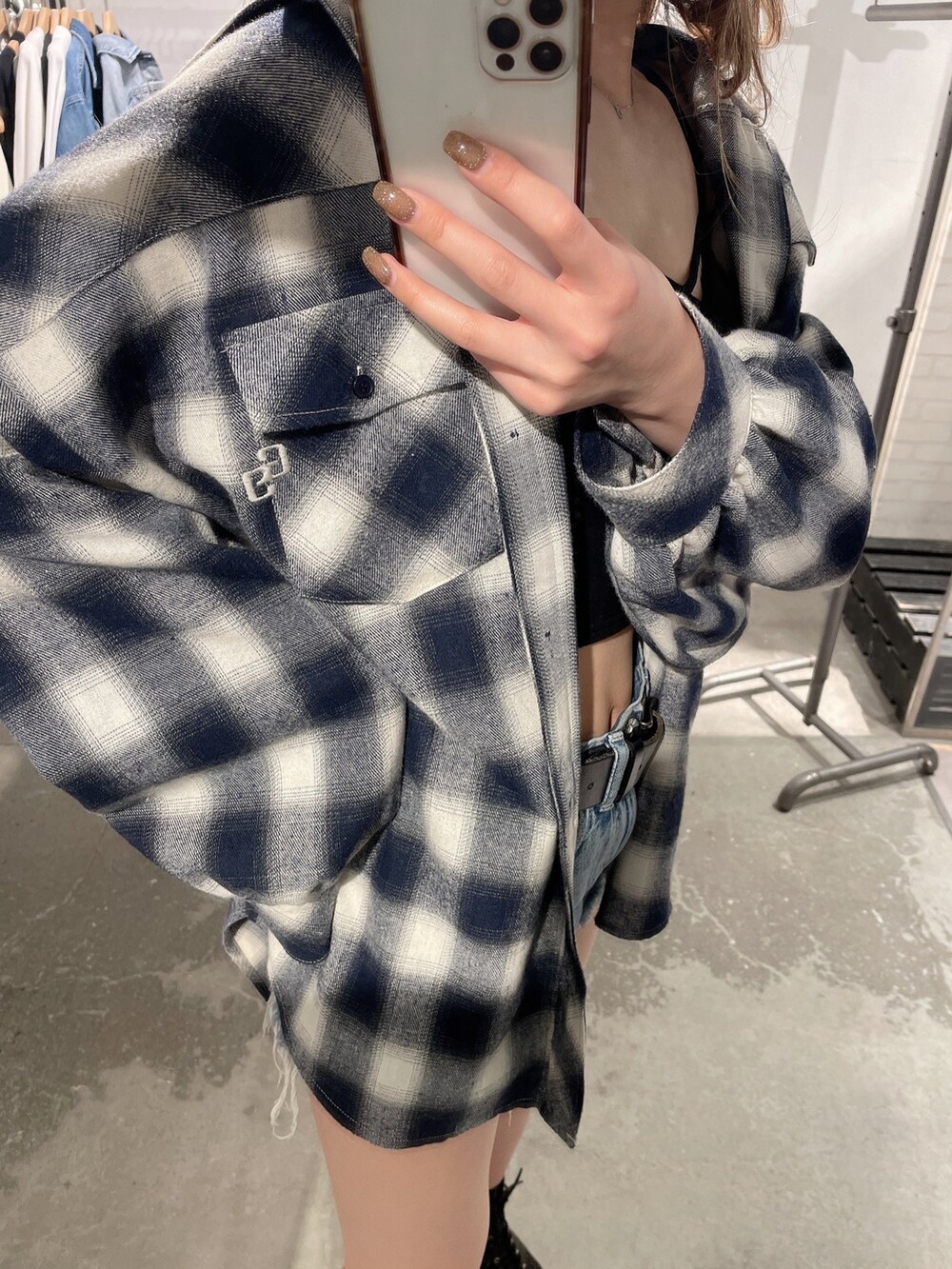 ブラック系のブーツ、ブラック系のキャミソール、ブルー系のデニムパンツを着用したレディースの春コーディネートの6枚目の写真