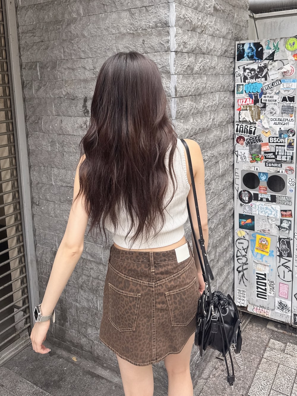 ホワイト系のニット/セーター、ベージュ系のスカート、ブラック系のサンダルを着用したレディースの夏コーディネートの3枚目の写真