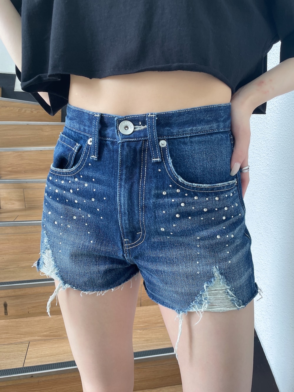 ブラック系のTシャツ/カットソー、ブルー系のデニムパンツ、ブラック系のサンダルを着用したレディースの春コーディネートの5枚目の写真