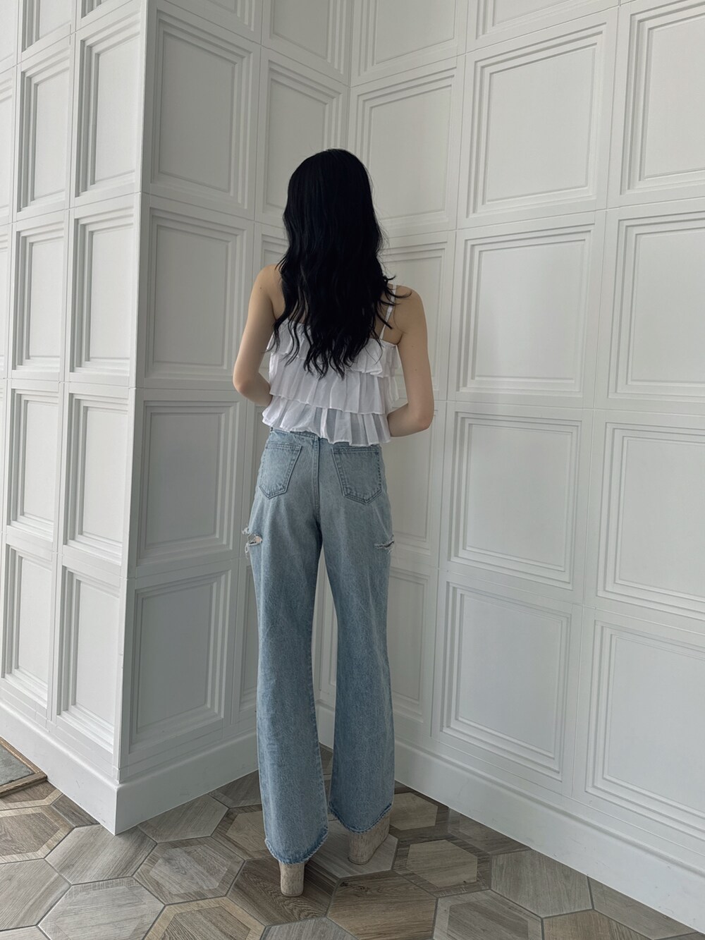 ホワイト系のキャミソール、ブルー系のデニムパンツ、ホワイト系のサンダルを着用したレディースの夏コーディネートの2枚目の写真