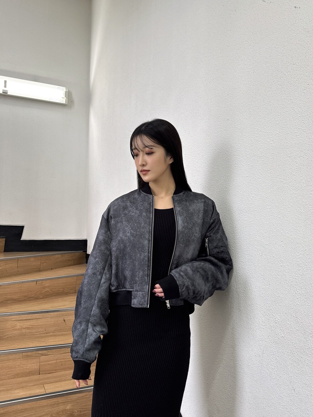 ブラック系のMA-1、ブラック系のワンピース、ブラック系のブーツを着用したレディースの秋コーディネートの3枚目の写真