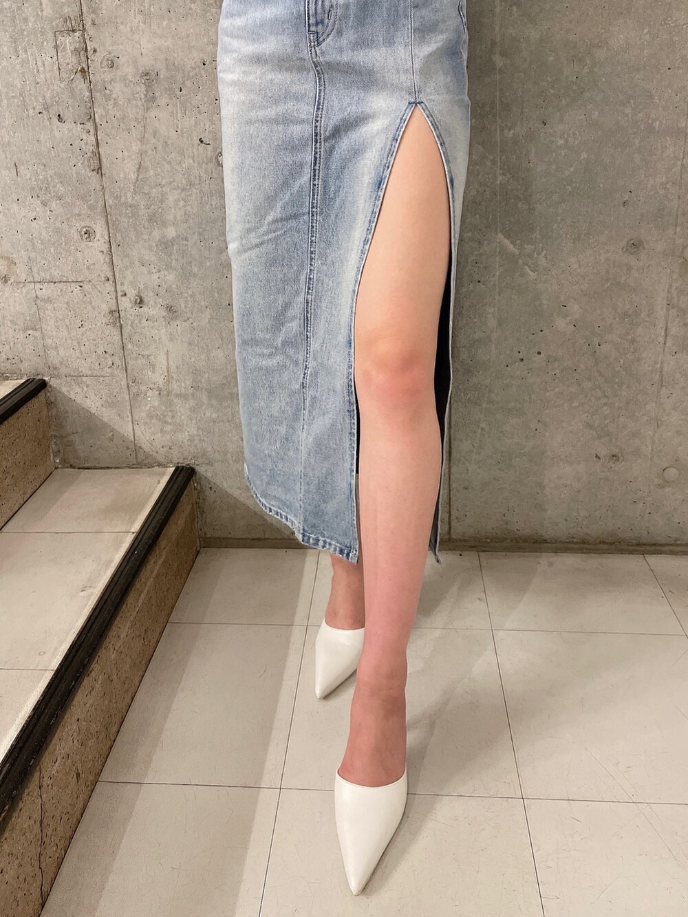 ホワイト系のパーカー、ブルー系のデニムスカート、ホワイト系のパンプスを着用したレディースの冬コーディネートの7枚目の写真