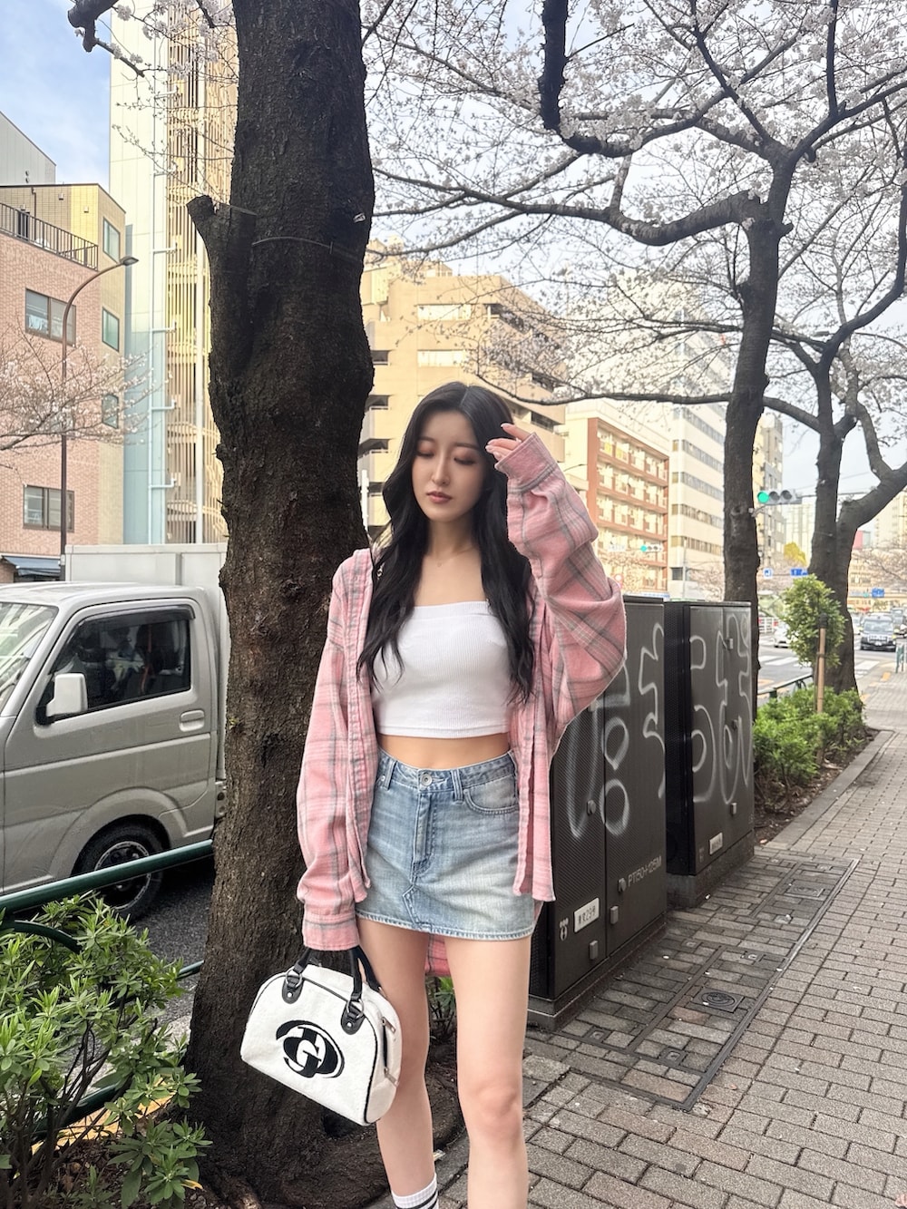 ホワイト系のキャミソール、ブルー系のデニムスカート、ホワイト系のサンダルを着用したレディースの春コーディネートの3枚目の写真