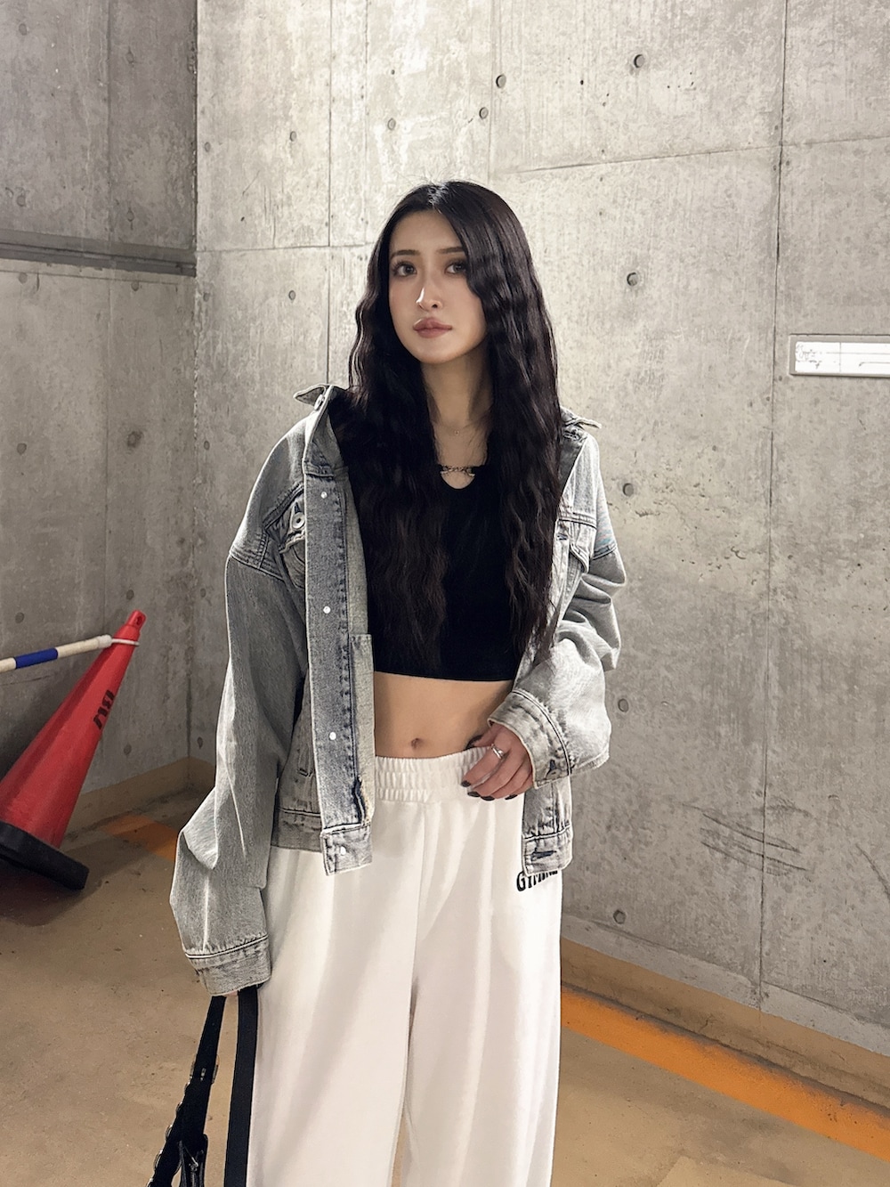 ブルー系のデニムジャケット、ブラック系のTシャツ/カットソー、ホワイト系のスウェットパンツを着用したレディースの春コーディネートの2枚目の写真