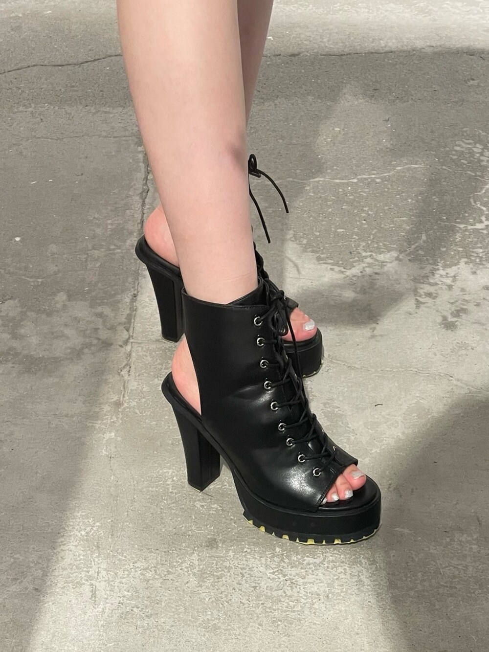 ホワイト系のニット/セーター、ブラック系のデニムスカート、ブラック系のブーツを着用したレディースの夏コーディネートの7枚目の写真