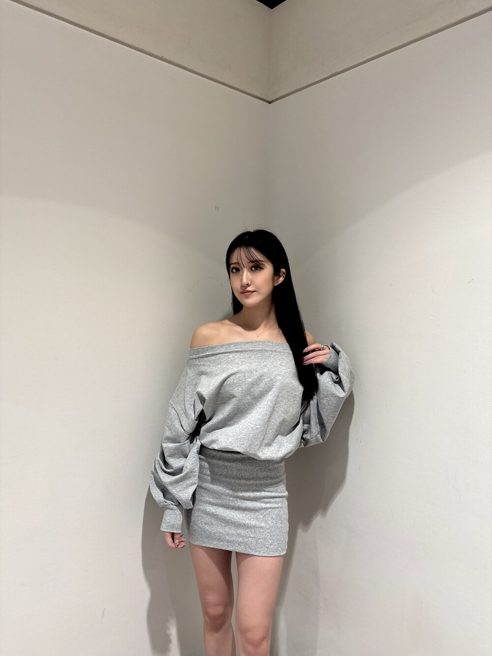 グレー系のワンピース、ブラック系のブーツを着用したレディースの冬コーディネートの3枚目の写真