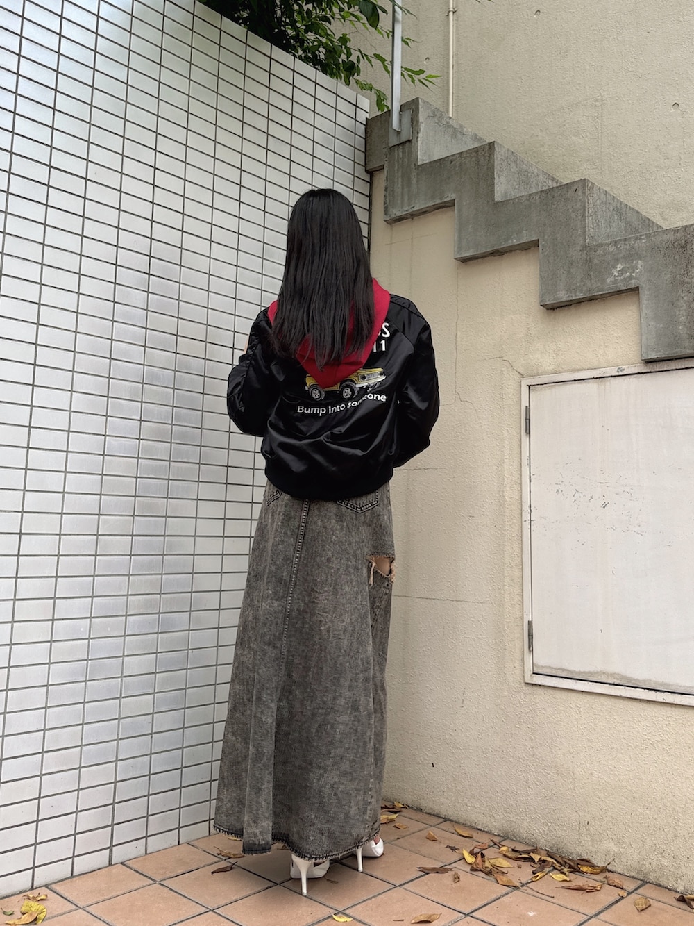 ブラック系のブルゾン、レッド系のパーカー、ブラック系のデニムスカートを着用したレディースの秋コーディネートの2枚目の写真