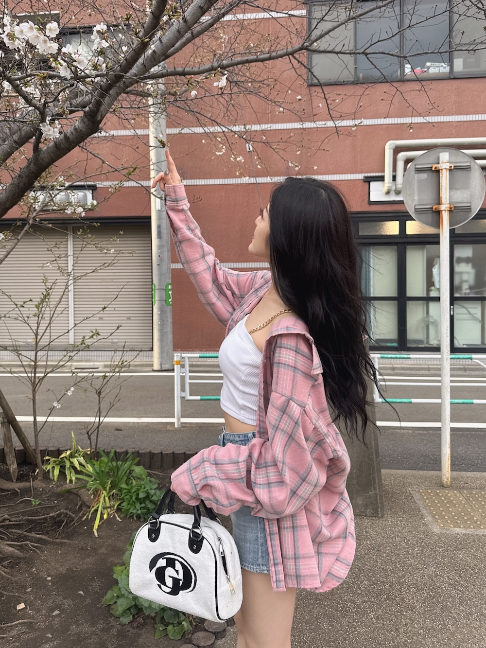 ホワイト系のキャミソール、ブルー系のデニムスカート、ホワイト系のサンダルを着用したレディースの春コーディネートの4枚目の写真