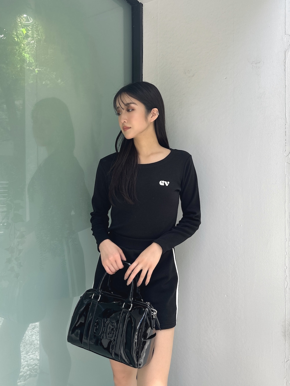 ブラック系のTシャツ/カットソー、ブラック系のスカート、ブラック系のブーツを着用したレディースの秋コーディネートの4枚目の写真