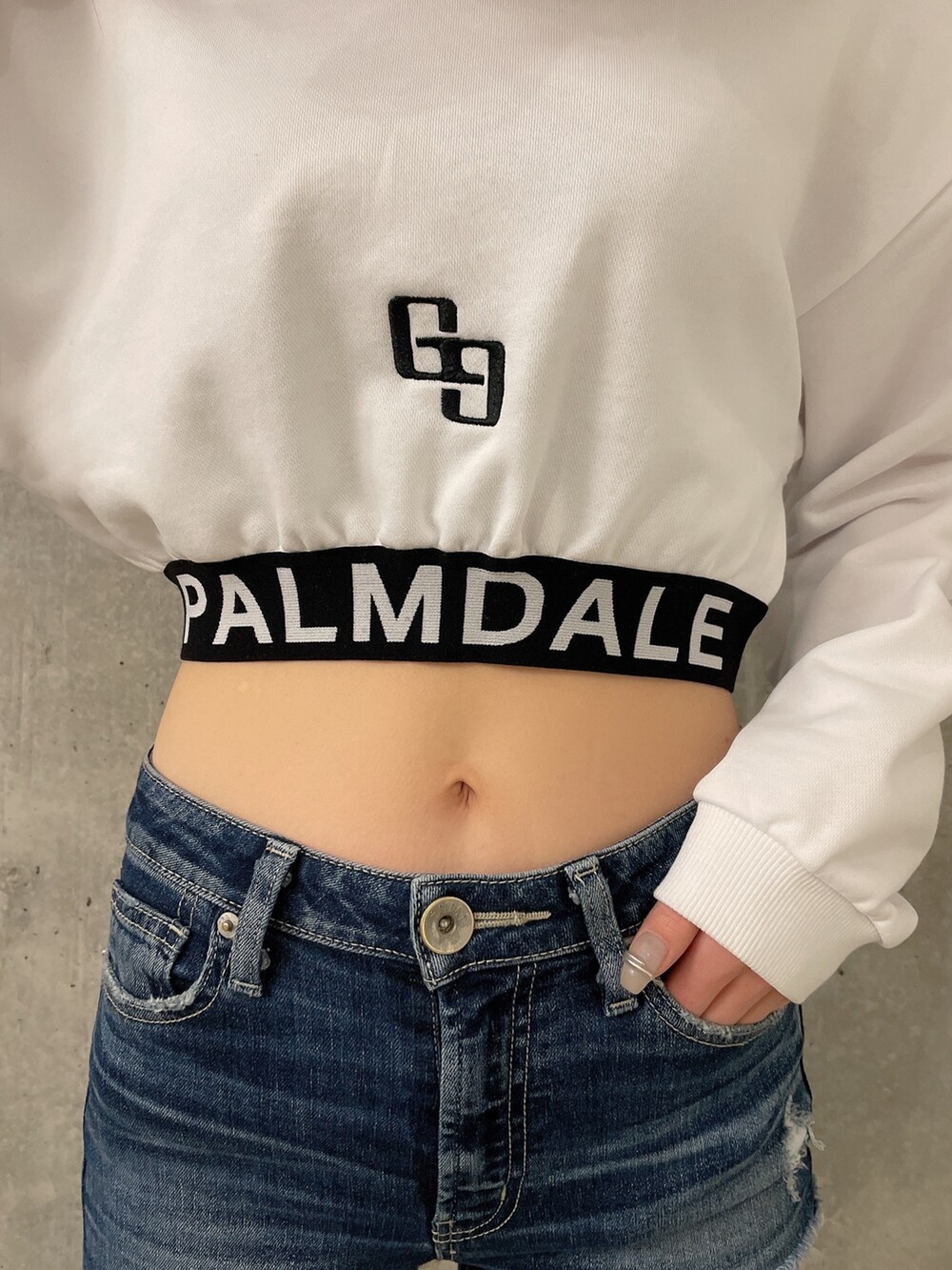 ホワイト系のスウェット、ブルー系のデニムパンツ、ホワイト系のスニーカーを着用したレディースの冬コーディネートの4枚目の写真
