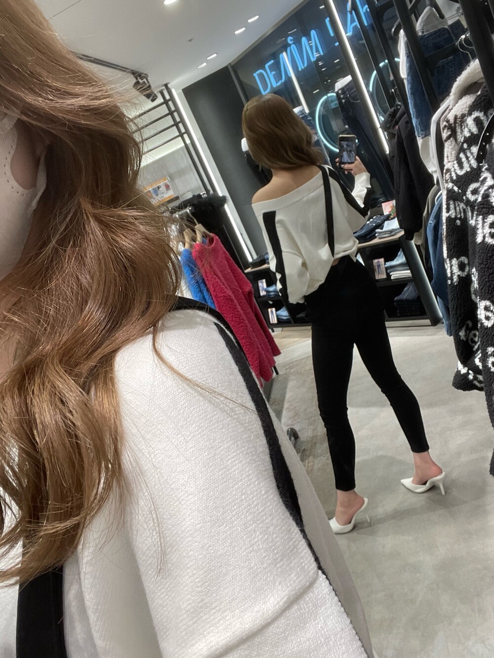 ホワイト系のニット/セーター、ブラック系のサロペット/オーバーオール、ホワイト系のパンプスを着用したレディースの冬コーディネートの5枚目の写真