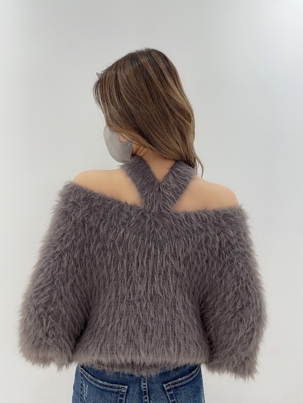 ブルー系のデニムパンツ、グレー系のニット/セーター、ブラック系のブーツを着用したレディースの冬コーディネートの4枚目の写真