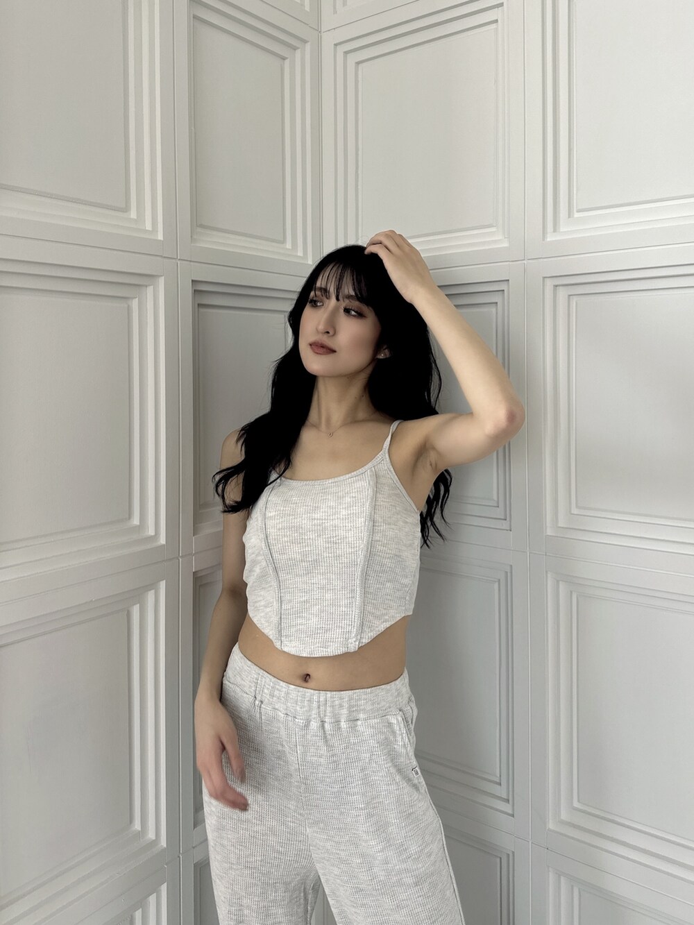 グレー系のキャミソール、グレー系のスウェットパンツ、ブラック系のパンプスを着用したレディースの夏コーディネートの3枚目の写真