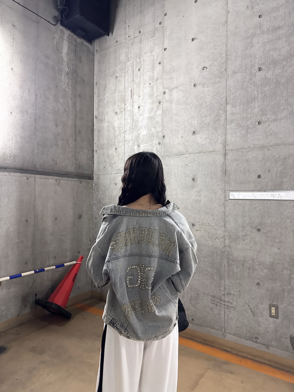 ブルー系のデニムジャケット、ブラック系のTシャツ/カットソー、ホワイト系のスウェットパンツを着用したレディースの春コーディネートの3枚目の写真