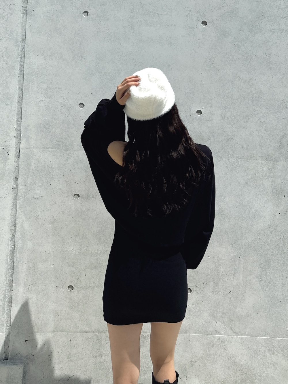 ブラック系のワンピース、ブラック系のブーツ、ホワイト系のニットキャップ/ビーニーを着用したレディースの秋コーディネートの5枚目の写真