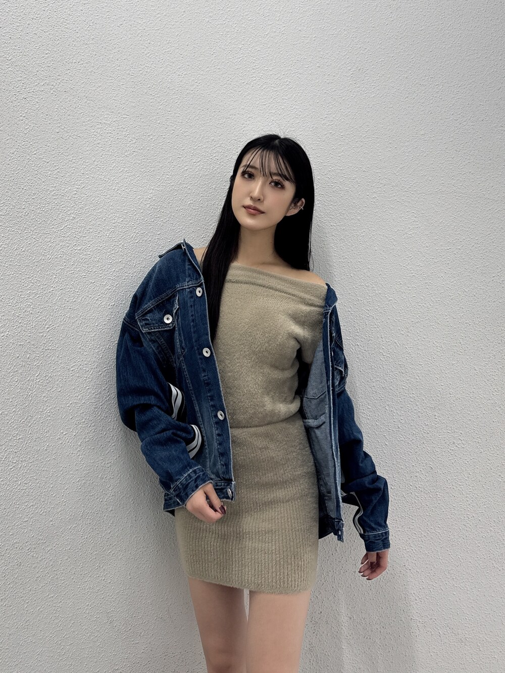 ブルー系のデニムジャケット、ベージュ系のワンピース、ブラック系のブーツを着用したレディースの秋コーディネートの3枚目の写真