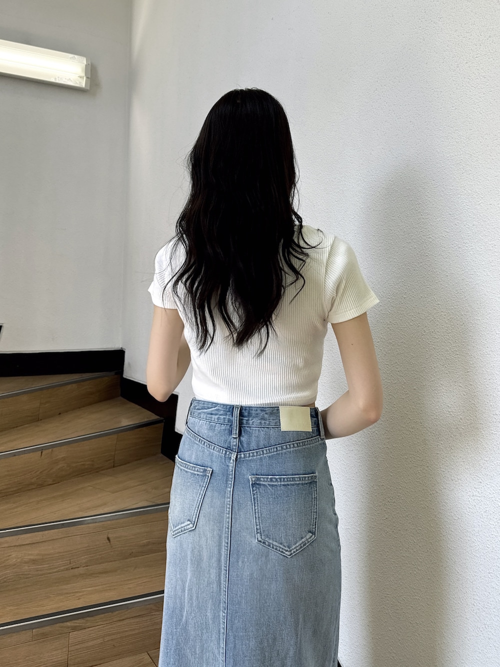 ホワイト系のTシャツ/カットソー、ブルー系のデニムスカート、ホワイト系のサンダルを着用したレディースの夏コーディネートの4枚目の写真