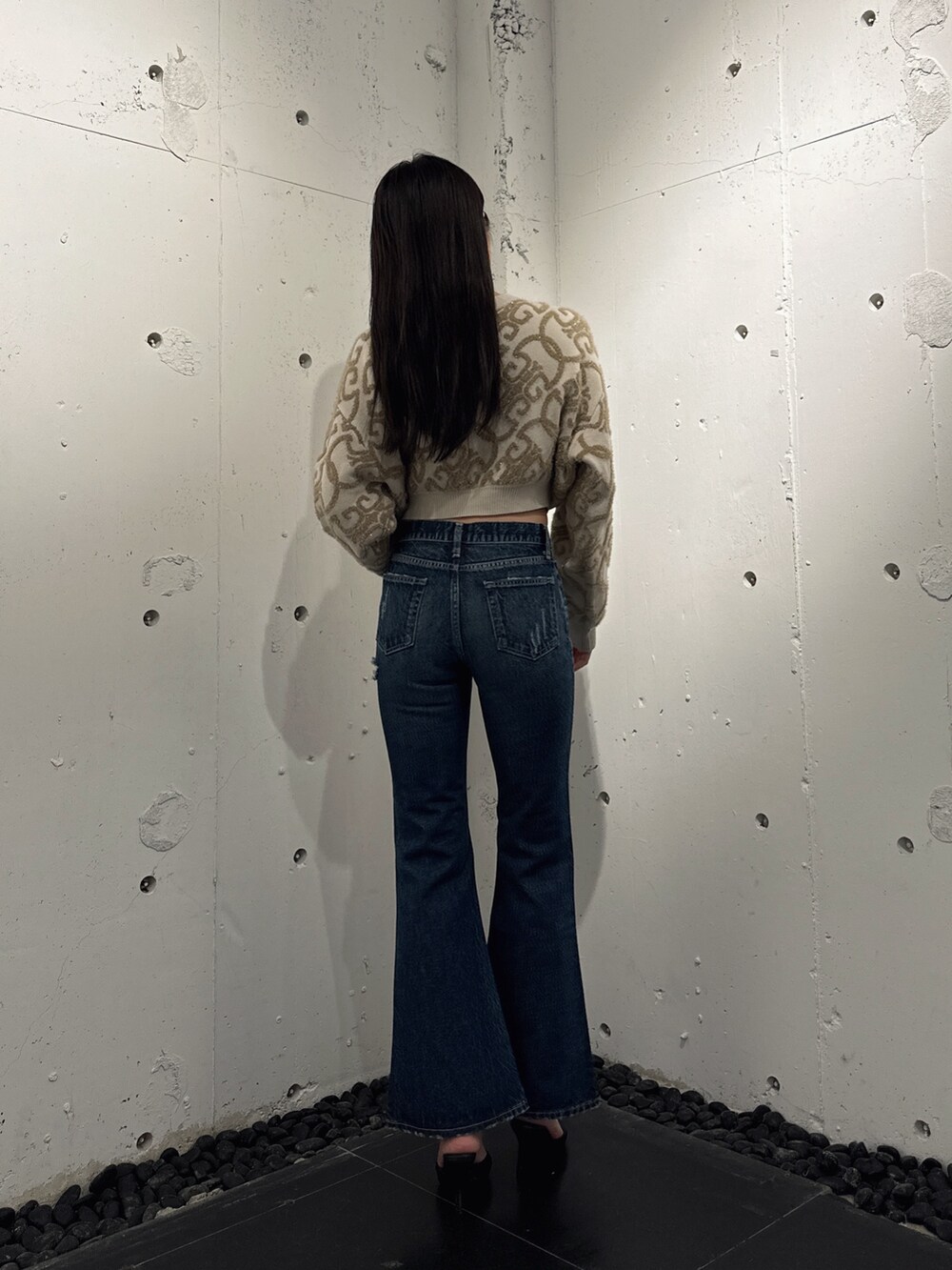 ホワイト系のニット/セーター、ブルー系のデニムパンツ、ブラック系のパンプスを着用したレディースの秋コーディネートの2枚目の写真
