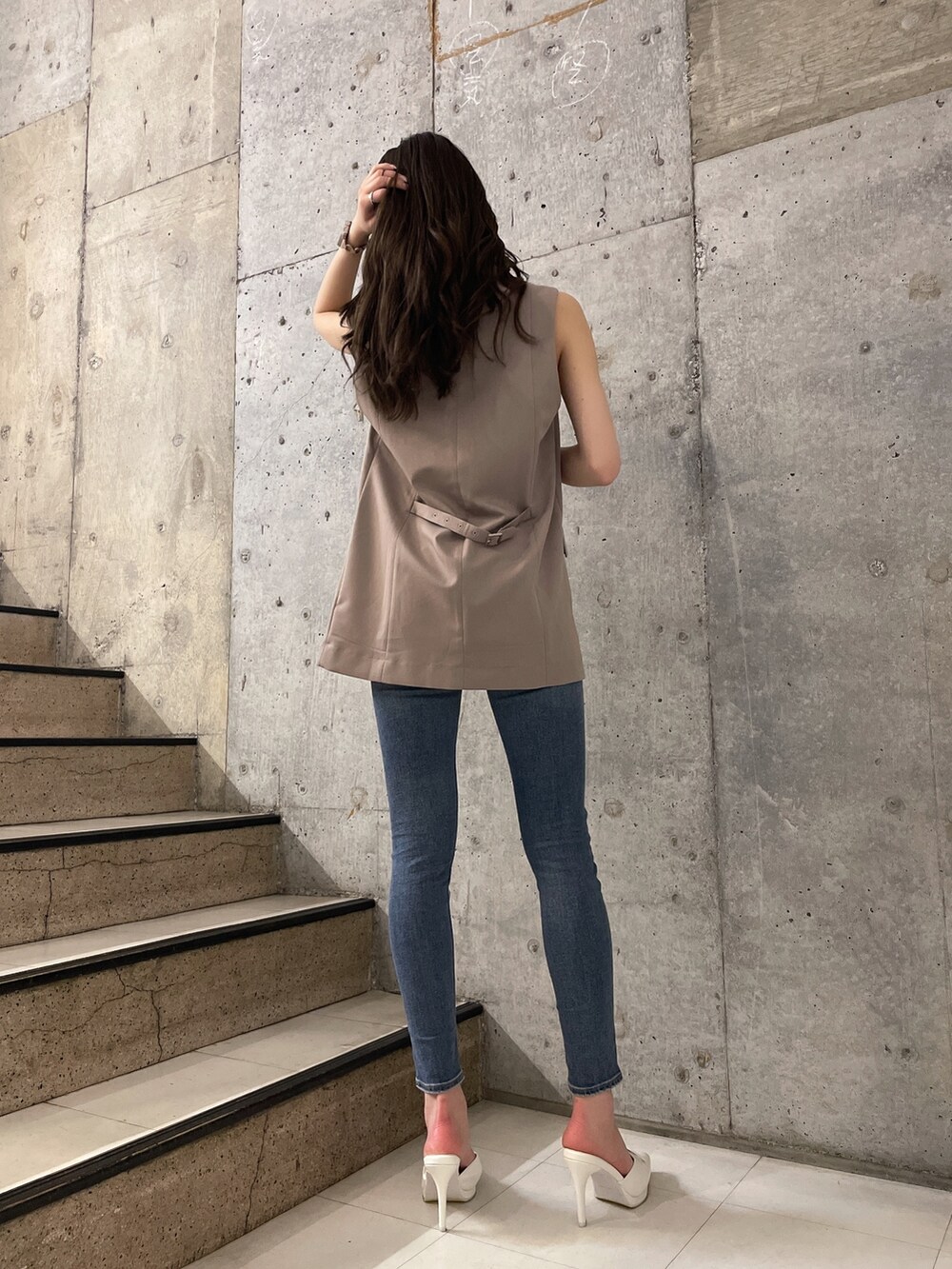 ホワイト系のニット/セーター、ブルー系のデニムパンツ、ホワイト系のパンプスを着用したレディースの春コーディネートの4枚目の写真