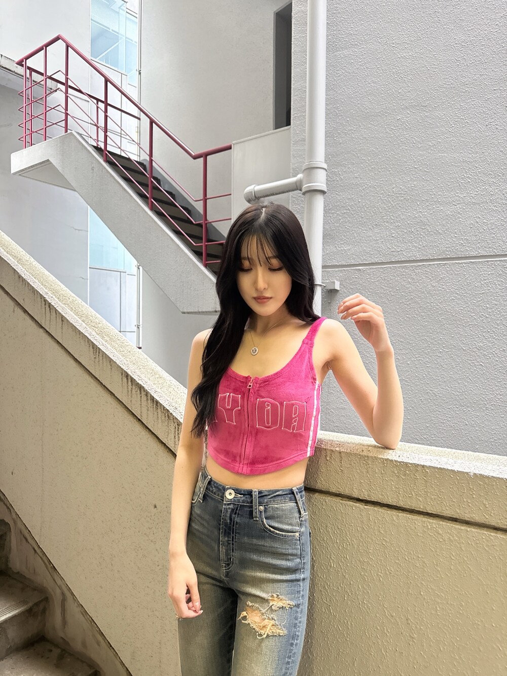 ピンク系のキャミソール、ブルー系のデニムパンツ、ホワイト系のパンプスを着用したレディースの夏コーディネートの2枚目の写真