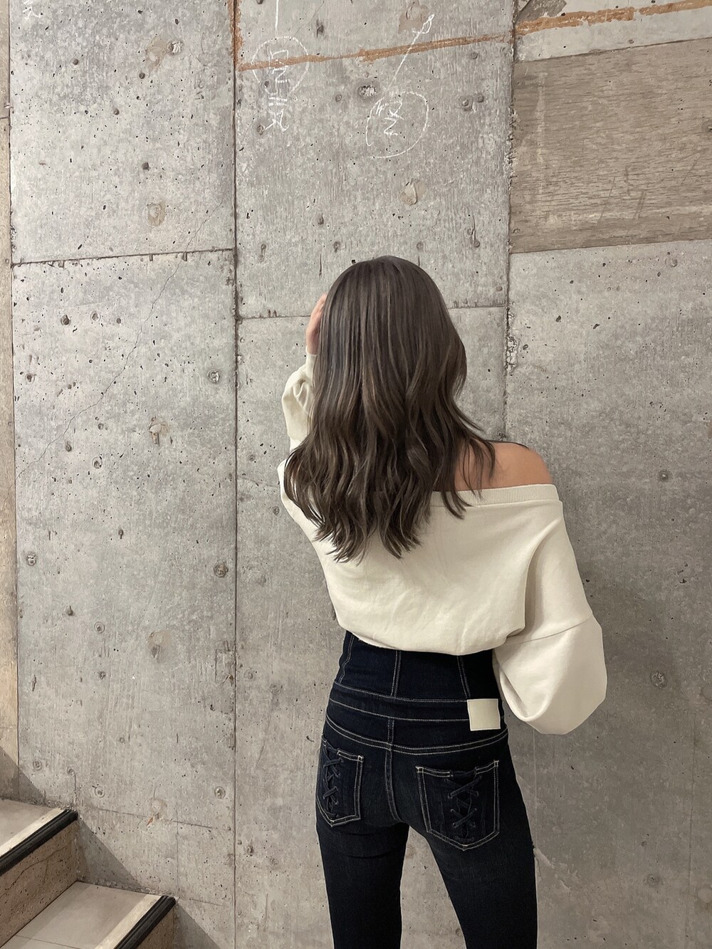 ホワイト系のスウェット、ブルー系のデニムパンツ、ブラック系のパンプスを着用したレディースの夏コーディネートの4枚目の写真