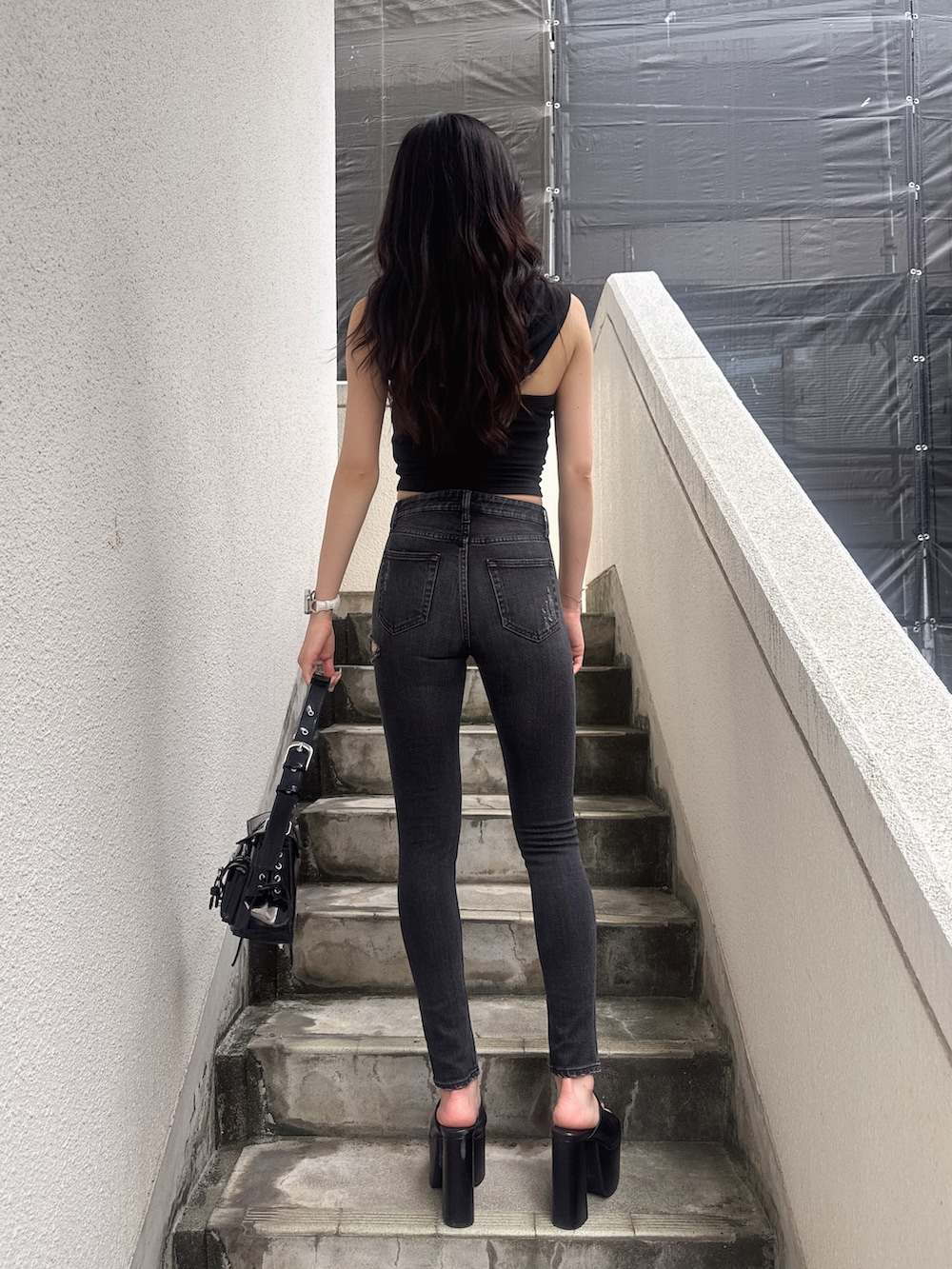 ブラック系のTシャツ/カットソー、ブラック系のデニムパンツ、ブラック系のサンダルを着用したレディースの夏コーディネートの4枚目の写真