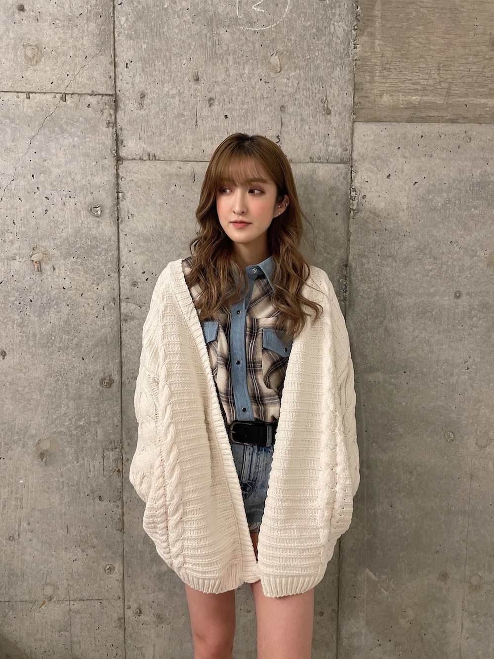 ホワイト系のカーディガン/ボレロ、ホワイト系のシャツ/ブラウス、ブラック系のブーツを着用したレディースの冬コーディネートの3枚目の写真