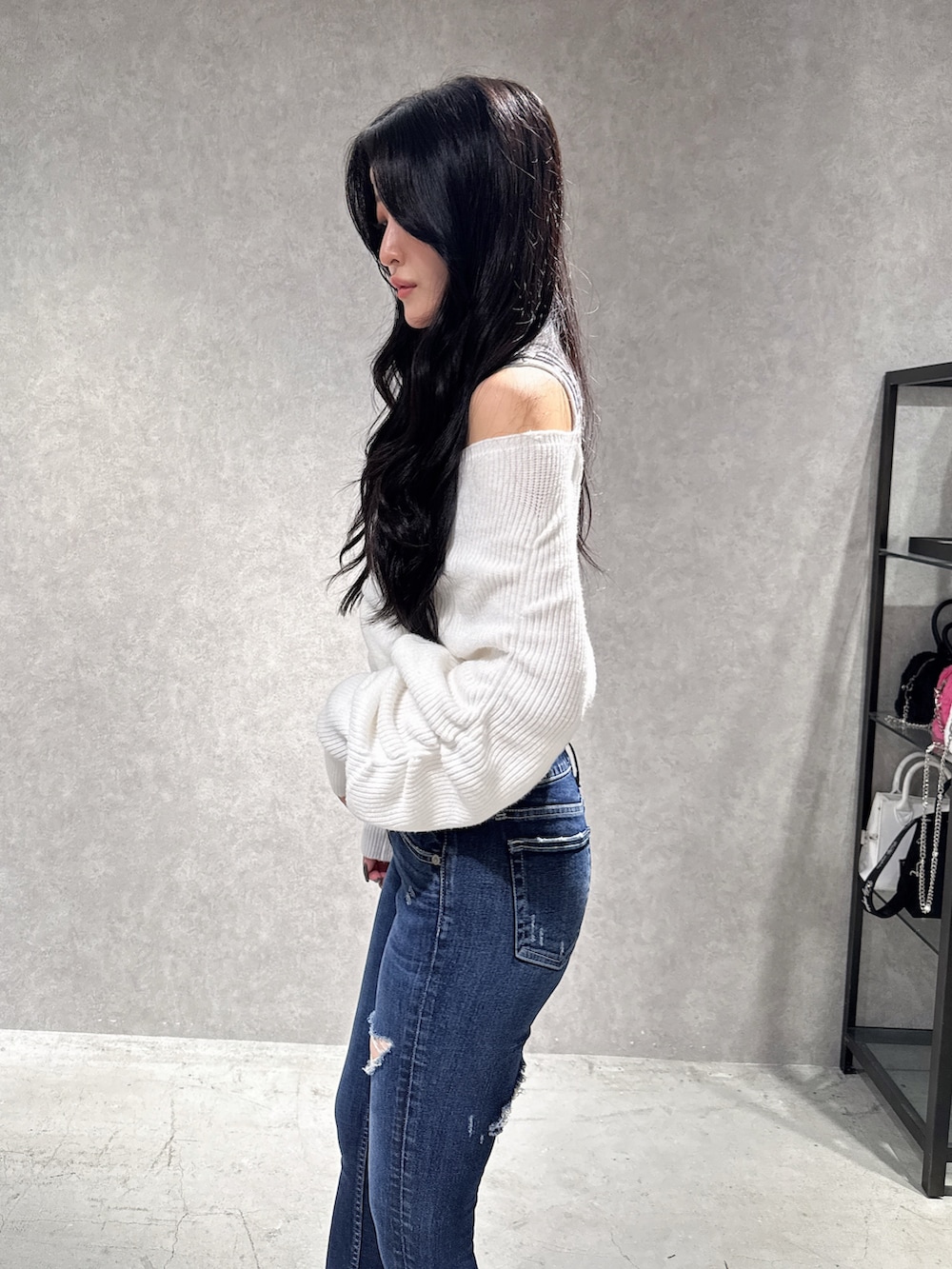 ホワイト系のニット/セーター、ブルー系のデニムパンツ、ブラック系のブーツを着用したレディースの秋コーディネートの5枚目の写真