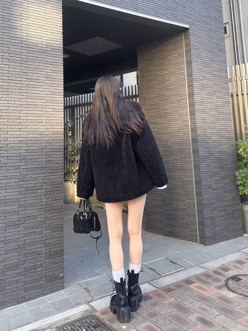 ホワイト系のニット/セーター、ブラック系のブルゾン、その他のデニムスカートを着用したレディースの冬コーディネートの3枚目の写真